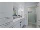 Elegant bathroom featuring double sinks, marble countertops, and custom cabinets for ample storage at 799 Jacaranda Rd, Anna Maria, FL 34216