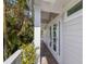 Inviting entrance with french doors, a covered porch, and lush tropical landscaping surrounding the doorway at 799 Jacaranda Rd, Anna Maria, FL 34216