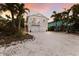 Charming two-story coastal home featuring a private balcony and spacious driveway with lush landscaping at 799 Jacaranda Rd, Anna Maria, FL 34216