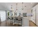 Bright kitchen features an island with seating, pendant lighting, and white cabinets at 799 Jacaranda Rd, Anna Maria, FL 34216