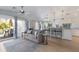 Cozy living space featuring a comfortable couch, kitchen bar, and natural light from the adjacent balcony at 799 Jacaranda Rd, Anna Maria, FL 34216
