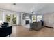 Bright living room with a fireplace, TV, and double doors leading to a charming outdoor balcony at 799 Jacaranda Rd, Anna Maria, FL 34216