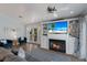 Bright living room featuring a fireplace, TV, and double doors leading to a charming outdoor balcony at 799 Jacaranda Rd, Anna Maria, FL 34216