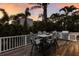 Outdoor deck with a dining area, grill, and lush tropical surroundings, perfect for outdoor gatherings at 799 Jacaranda Rd, Anna Maria, FL 34216