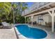 Inviting pool area featuring lush tropical landscaping and comfortable lounge chairs at 799 Jacaranda Rd, Anna Maria, FL 34216