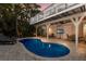 Inviting backyard pool with brick patio, lounge chairs, and outdoor TV for relaxing and entertaining at 799 Jacaranda Rd, Anna Maria, FL 34216
