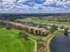 Aerial view of community with golf course, lakes, and residential buildings, showcasing its scenic layout at 8105 Grand Estuary Trl # 105, Bradenton, FL 34212