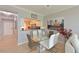 Bright dining area features a glass table, stylish seating, and views into an open kitchen at 8105 Grand Estuary Trl # 105, Bradenton, FL 34212