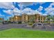 Well-maintained condo building with covered parking, lush landscaping, and a manicured lawn at 8105 Grand Estuary Trl # 105, Bradenton, FL 34212