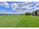 Scenic golf course view with a serene lake, blue skies, and lush green grass in a well-maintained community at 8105 Grand Estuary Trl # 105, Bradenton, FL 34212