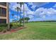 Scenic view of a golf course from the side of a building with palm trees on a sunny day at 8105 Grand Estuary Trl # 105, Bradenton, FL 34212
