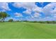 Picturesque golf course view with lush green grass, mature trees, and scenic water features in the background at 8105 Grand Estuary Trl # 105, Bradenton, FL 34212