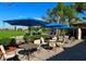 Inviting outdoor patio with comfortable seating, blue umbrellas, and golf course views at 8105 Grand Estuary Trl # 105, Bradenton, FL 34212