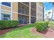 Exterior view of a screened patio with comfortable seating, accessible from the well-maintained lawn at 8105 Grand Estuary Trl # 105, Bradenton, FL 34212