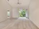 Bright bedroom featuring neutral carpeting, a ceiling fan, and sliding glass doors that open to a private balcony at 8315 Glenrose Way # 1421, Sarasota, FL 34238