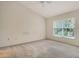 Bedroom featuring neutral carpet, a ceiling fan, and a window for natural light at 8315 Glenrose Way # 1421, Sarasota, FL 34238