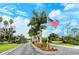 Pinestone community entrance with palm trees and American flag at 8315 Glenrose Way # 1421, Sarasota, FL 34238