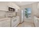 Cozy kitchen features bright white cabinets and appliances and tile flooring at 8315 Glenrose Way # 1421, Sarasota, FL 34238