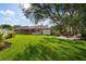 Large backyard with lush lawn, a screened lanai, and a charming firepit area at 8321 9Th Avenue Nw Ter, Bradenton, FL 34209