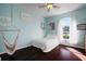 Bright bedroom featuring a ceiling fan, rich hardwood floors, and a whimsical hammock chair at 8321 9Th Avenue Nw Ter, Bradenton, FL 34209