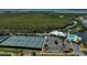 An aerial view of the community clubhouse featuring tennis courts, a pool, and serene waterfront views for recreational enjoyment at 939 Sandpiper Cir, Bradenton, FL 34209