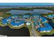 Aerial view of condo community featuring lake views, a pool, and well-maintained landscaping at 939 Sandpiper Cir, Bradenton, FL 34209