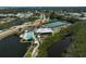 An aerial view of the community featuring a clubhouse, pool, tennis courts, and scenic water views for active living at 939 Sandpiper Cir, Bradenton, FL 34209