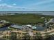 An aerial view of the community clubhouse, tennis courts, and swimming pool nestled amidst lush landscaping and tranquil waters at 939 Sandpiper Cir, Bradenton, FL 34209
