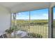 Enjoy water views from the screened balcony featuring comfortable seating and greenery at 939 Sandpiper Cir, Bradenton, FL 34209