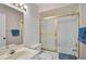 Classic bathroom with vanity, toilet, and enclosed tub featuring gold trim and white tile at 939 Sandpiper Cir, Bradenton, FL 34209