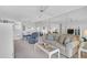 Bright living room with plush seating, white furnishings, and an open floor plan with eat-in kitchen at 939 Sandpiper Cir, Bradenton, FL 34209