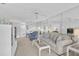 Bright living room with plush seating, white furnishings, and an open floor plan with kitchen and TV at 939 Sandpiper Cir, Bradenton, FL 34209