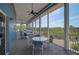 Inviting outdoor screened porch featuring seating and views of lush greenery and the blue sky at 939 Sandpiper Cir, Bradenton, FL 34209