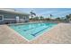 Community pool with clear blue water, surrounded by lounge chairs and beautiful landscaping at 939 Sandpiper Cir, Bradenton, FL 34209