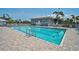 Community pool with clear blue water, surrounded by lounge chairs and beautiful landscaping at 939 Sandpiper Cir, Bradenton, FL 34209