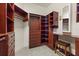 Spacious walk-in closet with custom wood shelving, drawers, and a built-in vanity area at 9769 Highland Park Pl, Palmetto, FL 34221