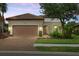 Dusk view of a single-story home with lush lawn and mature landscaping at 9769 Highland Park Pl, Palmetto, FL 34221