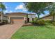 Charming single-story home with a well-manicured lawn, brick driveway, and a two-car garage at 9769 Highland Park Pl, Palmetto, FL 34221
