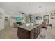 An open layout with a kitchen island flowing into a living and dining area at 9769 Highland Park Pl, Palmetto, FL 34221