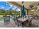 Outdoor kitchen and dining area with a built-in grill and a screened-in view of the pool at 9769 Highland Park Pl, Palmetto, FL 34221
