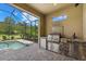 Outdoor kitchen area with a built-in grill and a screened-in view of the pool and yard at 9769 Highland Park Pl, Palmetto, FL 34221