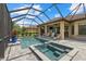 Covered patio overlooking a screened pool and spa with serene outdoor lounge area at 9769 Highland Park Pl, Palmetto, FL 34221
