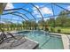 Stunning screened-in pool and jacuzzi area with comfortable lounge chairs, perfect for relaxation at 9769 Highland Park Pl, Palmetto, FL 34221