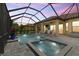 Twilight view of the screened pool and spa with covered patio at 9769 Highland Park Pl, Palmetto, FL 34221