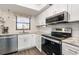 Well-lit kitchen featuring modern appliances, white cabinets, and sleek countertops at 104 Capri Isles Blvd # 207, Venice, FL 34292