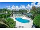 An inviting pool area with lounge chairs, landscaping, and a community clubhouse, perfect for relaxation at 104 Capri Isles Blvd # 207, Venice, FL 34292