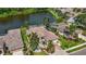 Aerial view of a home with a tile roof, screened pool, lake view, and lush landscaping at 10523 Old Grove Cir, Bradenton, FL 34212