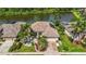 Beautiful aerial view of a home and lush landscaping with a lake in the background at 10523 Old Grove Cir, Bradenton, FL 34212
