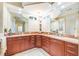 Luxurious bathroom with dual vanities, granite countertops, and a built-in makeup counter at 10523 Old Grove Cir, Bradenton, FL 34212