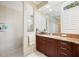 Bright bathroom featuring a tiled shower, vanity with granite top, and natural light at 10523 Old Grove Cir, Bradenton, FL 34212